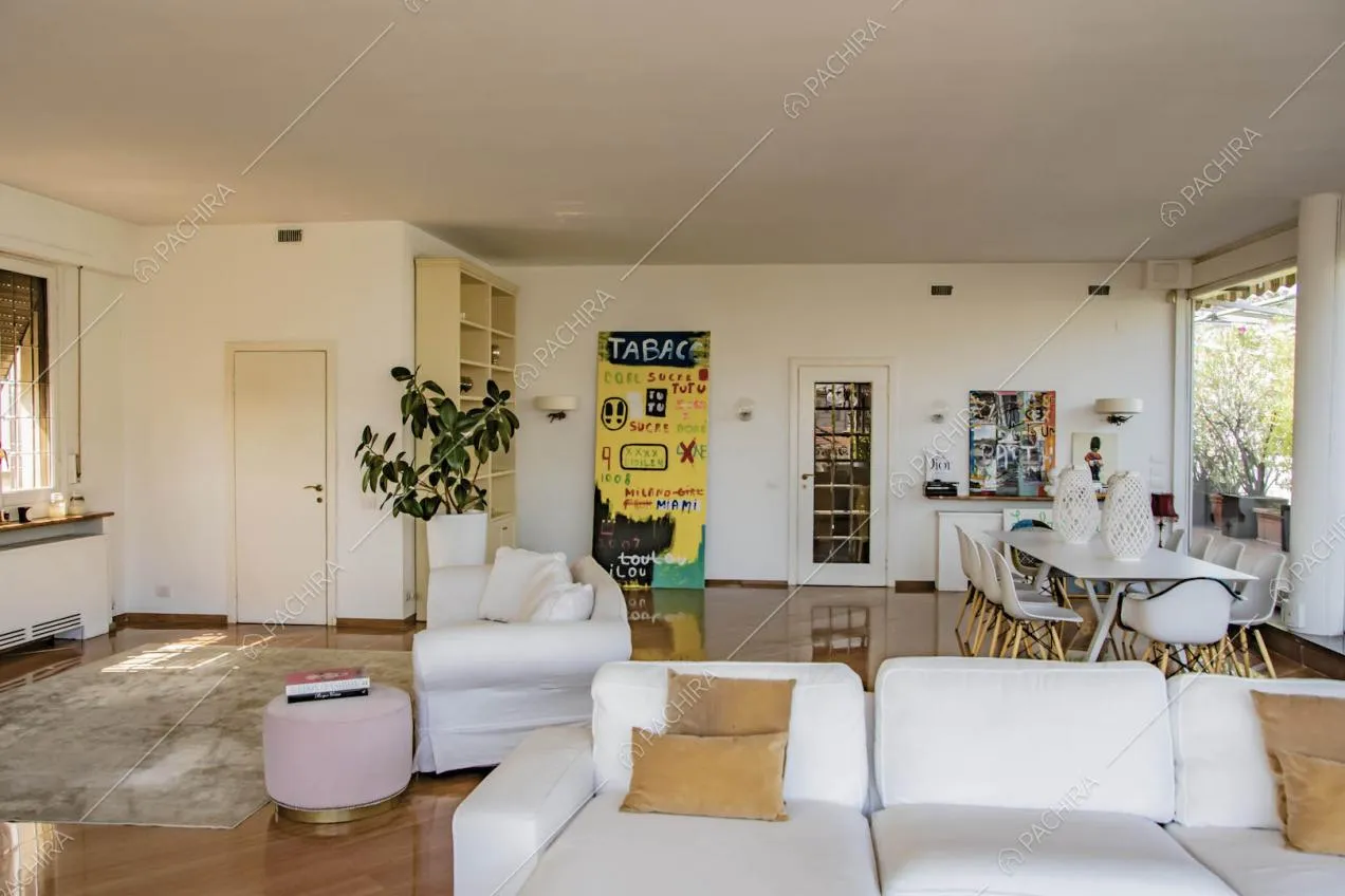Divani bianchi, tavolo da pranzo nella luminosa zona living con pavimento in parquet
