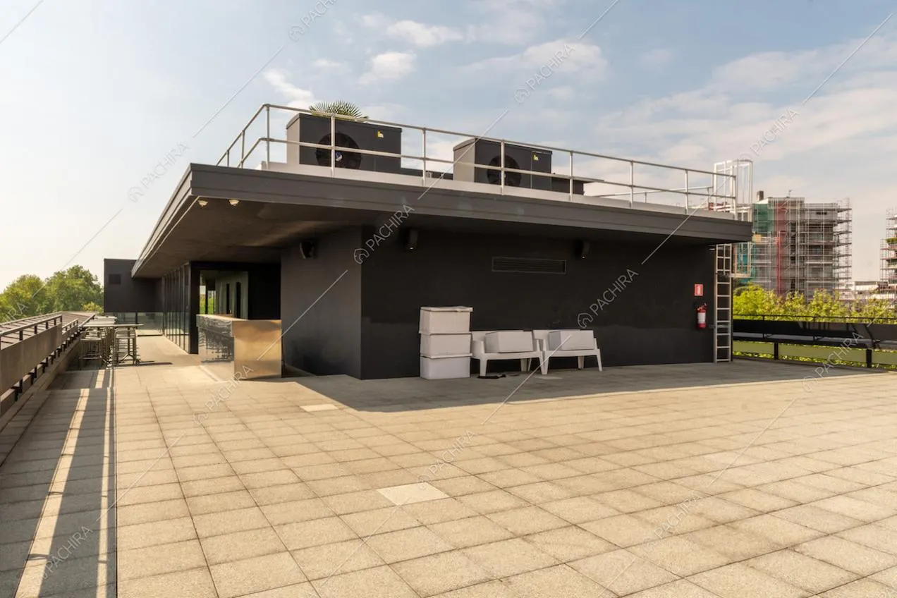 Ampia terrazza con vista su Milano e tavolini e sedie in metallo da esterno