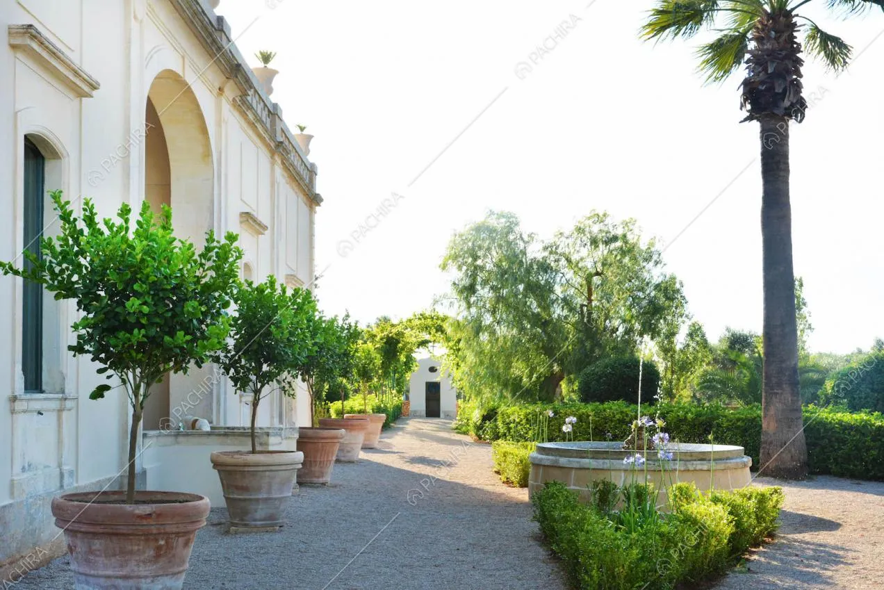 Giardino della villa con pavimentazione in ciottolato e vista sugli esterni bianchi