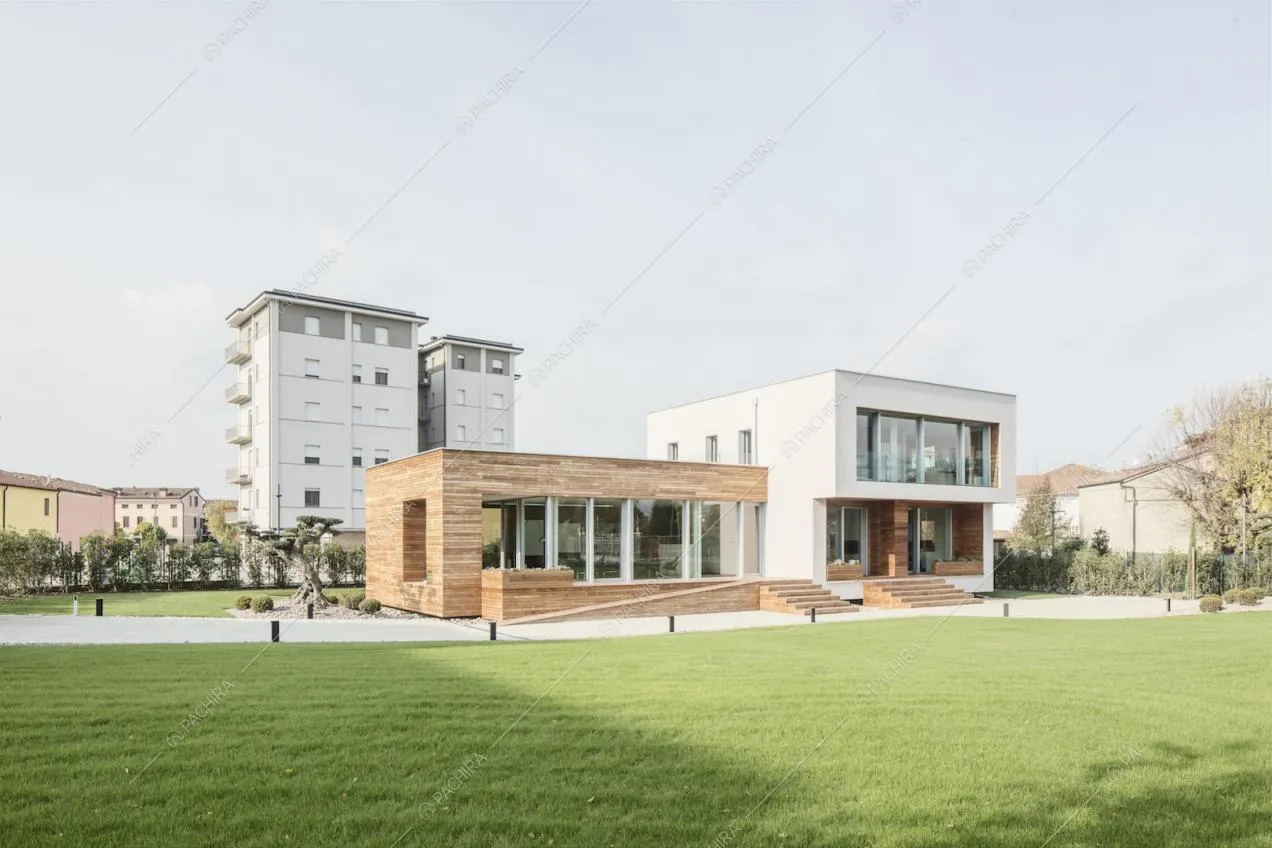 Dall'ampio giardino privato vista sulla villa, che si compone di due strutture, una in legno e una bianca, articolata su due piani