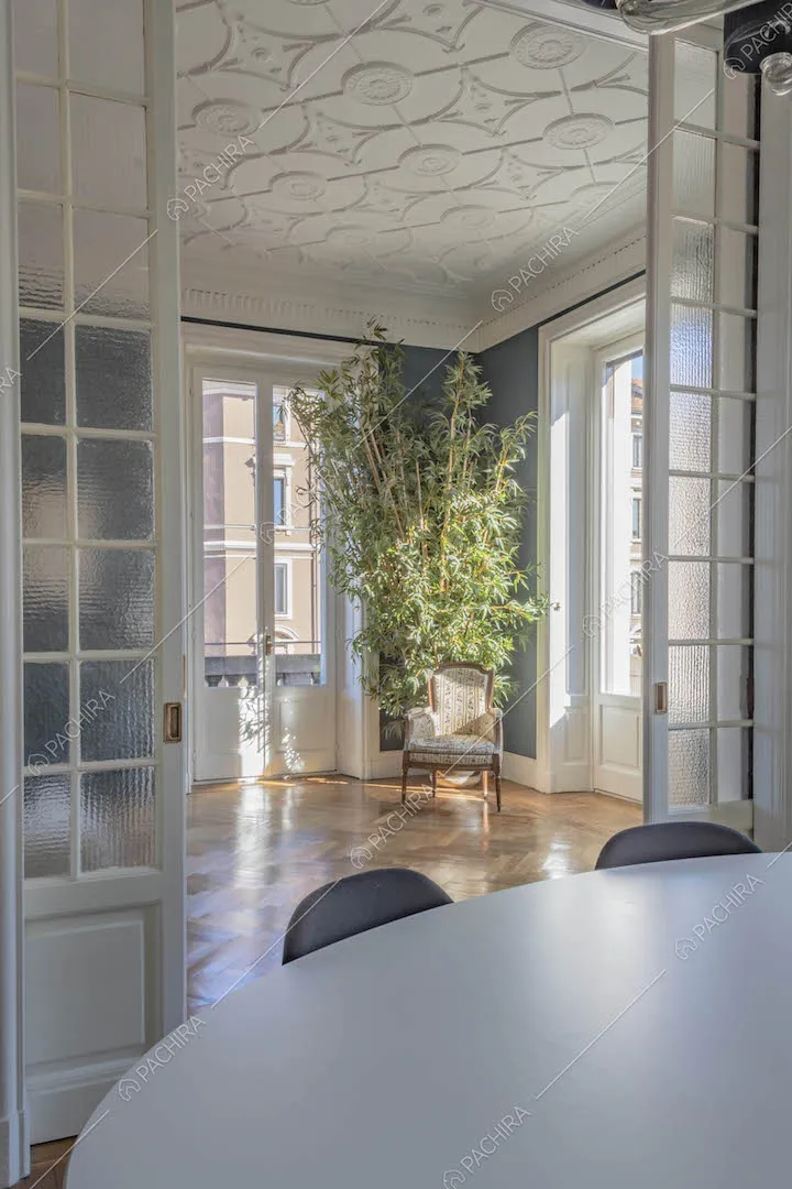 Dalla sala da pranzo vista sul soffitto con boiserie del luminoso salotto
