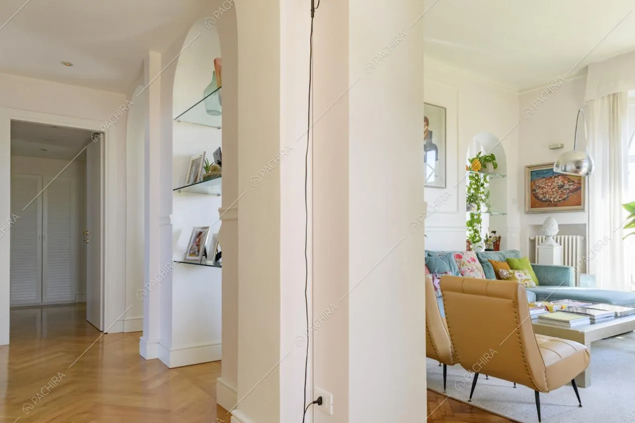 Vista dal corridoio sul salotto, arco e pavimento in parquet a spina di pesce
