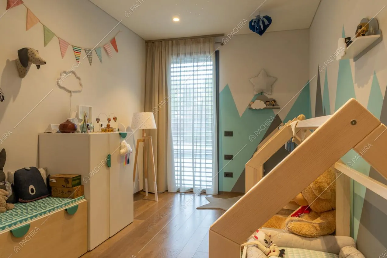 Camera da letto da bambini con pavimento in parquet e pareti azzurre e grigie