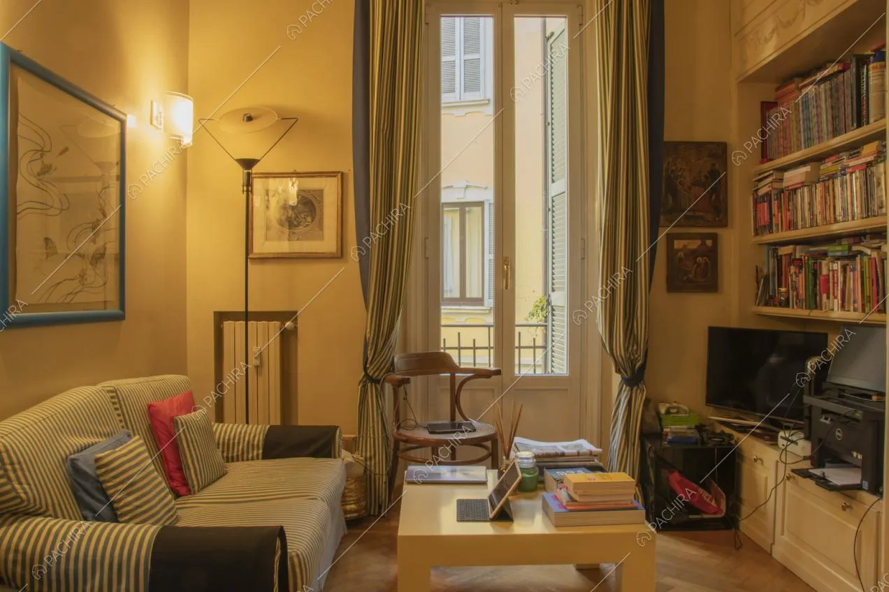 Divano e tende a righe sottili, porta finestra e tavolino quadrato giallo