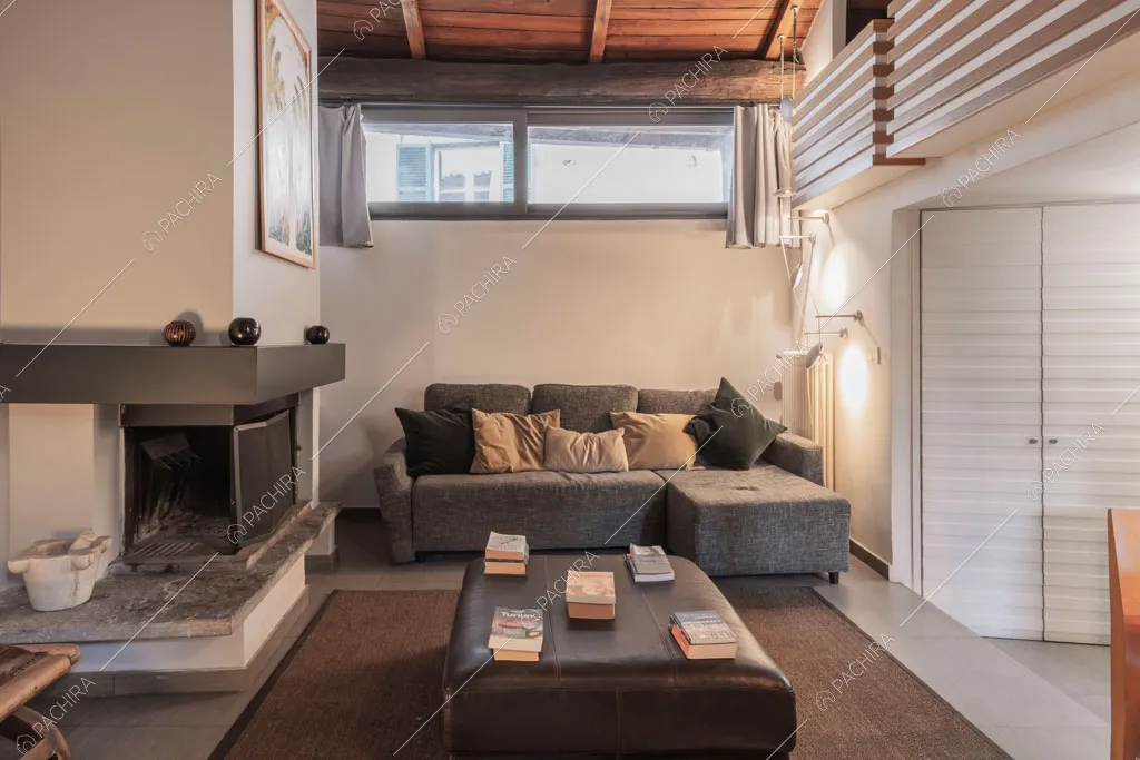 Salotto con camino del loft Berillio, location in stile contemporaneo a Roma