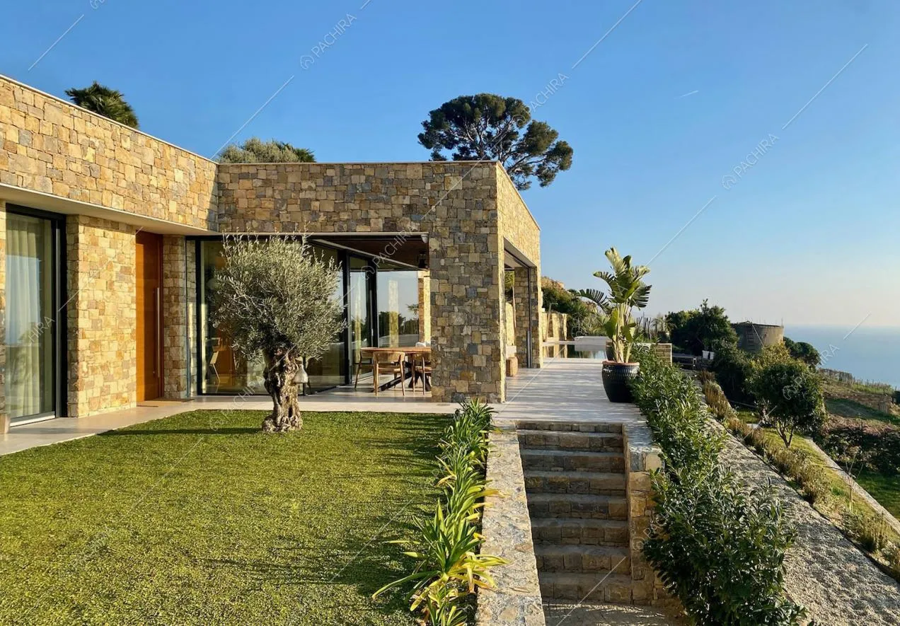Dal giardino vista sulla veranda, sul mare e sulle colline circostante