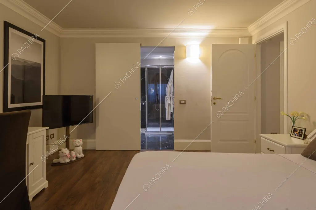Camera da letto con pavimento in parquet, scrivania e bagno privato con doccia
