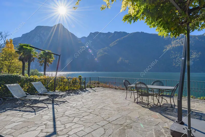 Lettini e tavolo da pranzo sulla grande terrazza con vista sul lago