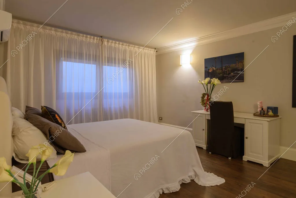 Camera da letto con scrivania bianca con boiserie e pavimento in parquet