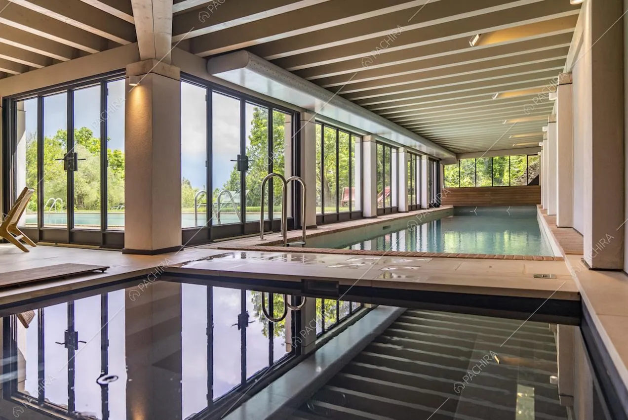 Grandi vetrate lungo le pareti che circondano la piscina