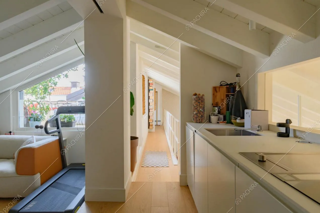 Cucina a parete a vista con fornelli a induzione e soffitto in travi in legno 