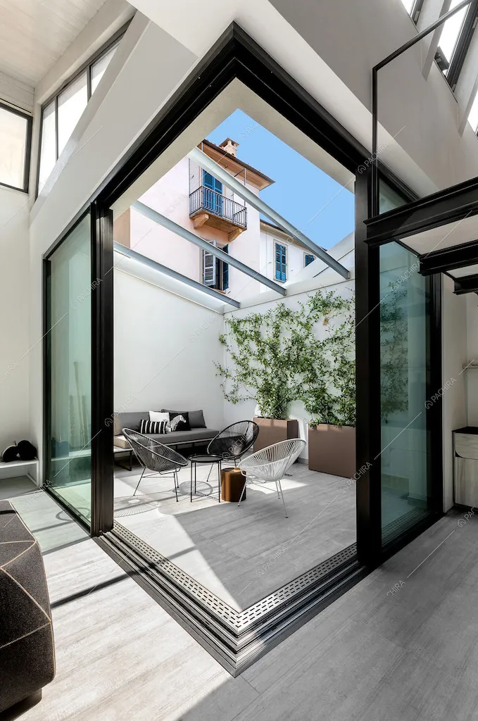 Giardino d'inverno dalle ampie vetrate con pavimento in parquet illumina tutto il loft