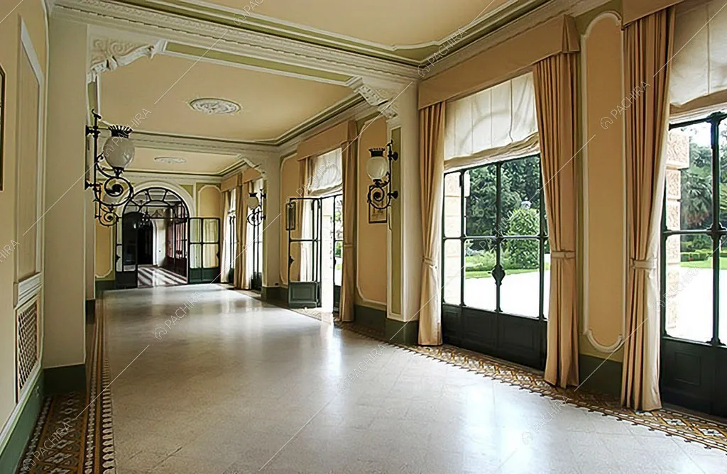Elegante corridoio con porte-finestre in metallo, pareti beige e boiserie sul soffitto