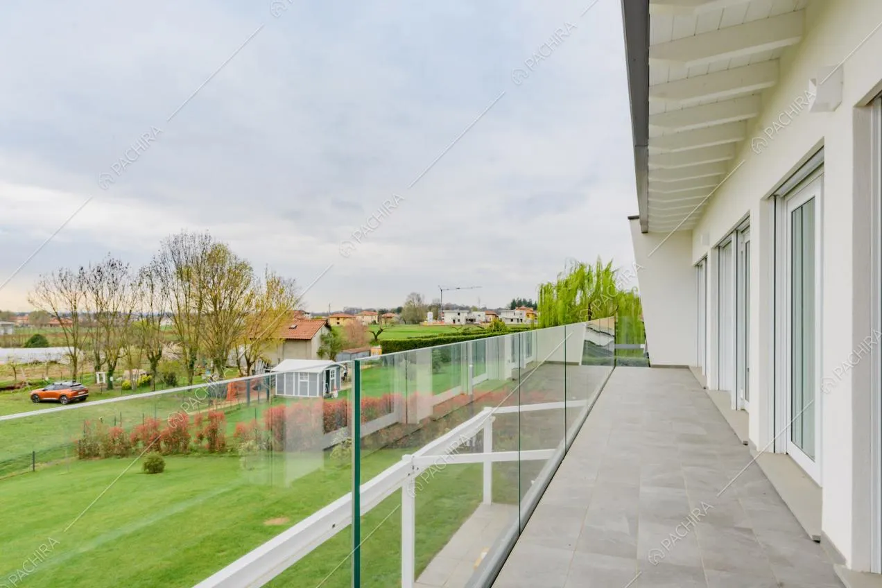 Terrazza con ringhiera in vetro e porte-finestre