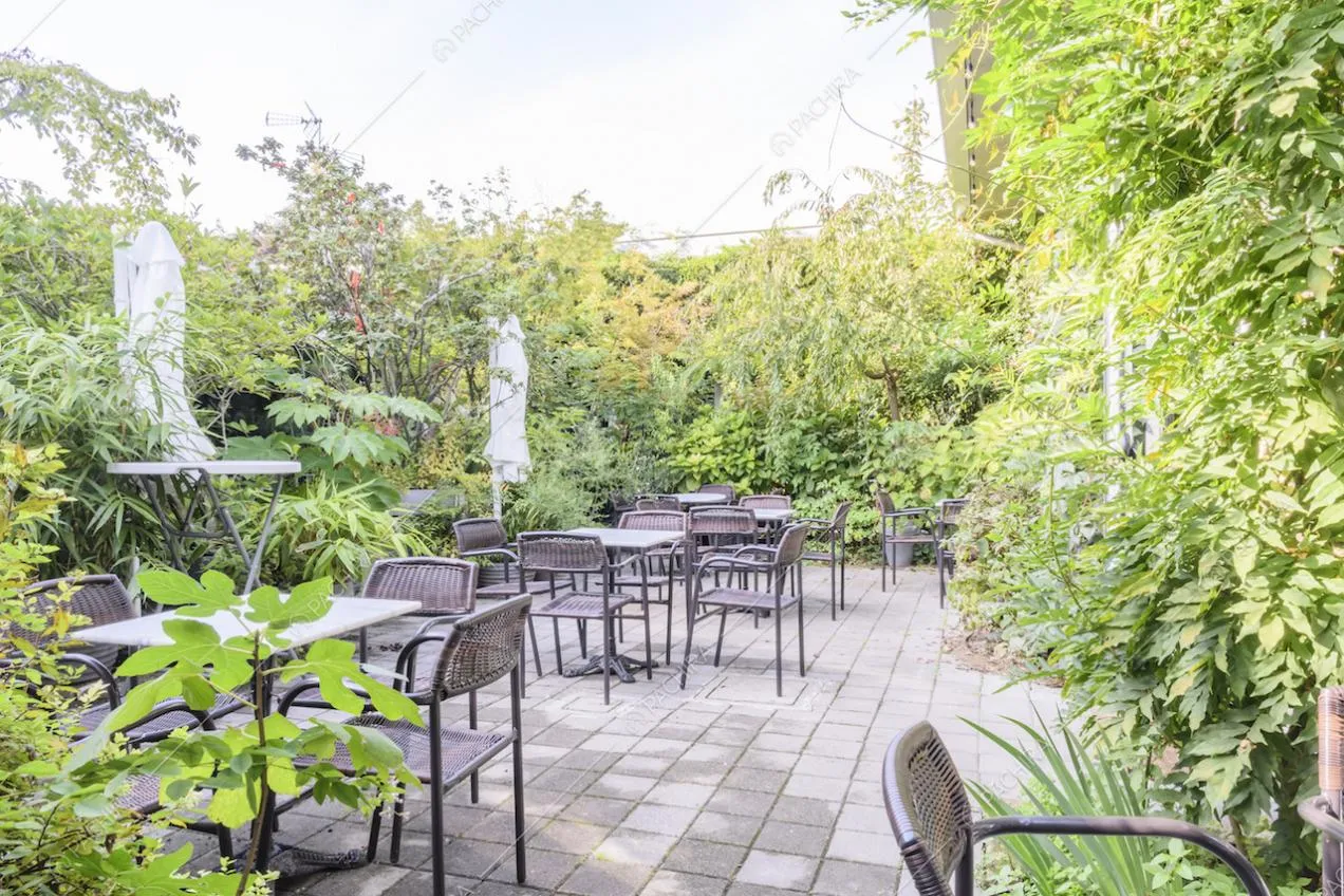Giardino con tavoli e sedie da esterni e ombrelloni bianchi