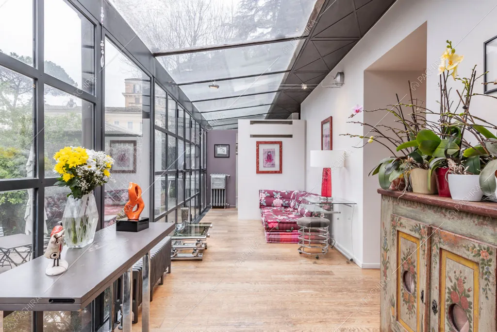 Pareti e soffitto vetrati nella veranda dell'appartamento Catalpa, location in stile moderno a Roma