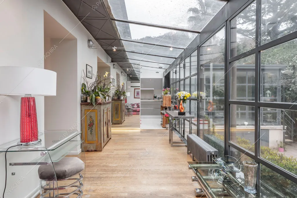 Pavimento in parquet e pareti vetrate nella veranda dell'appartamento Catalpa, location in stile moderno a Roma