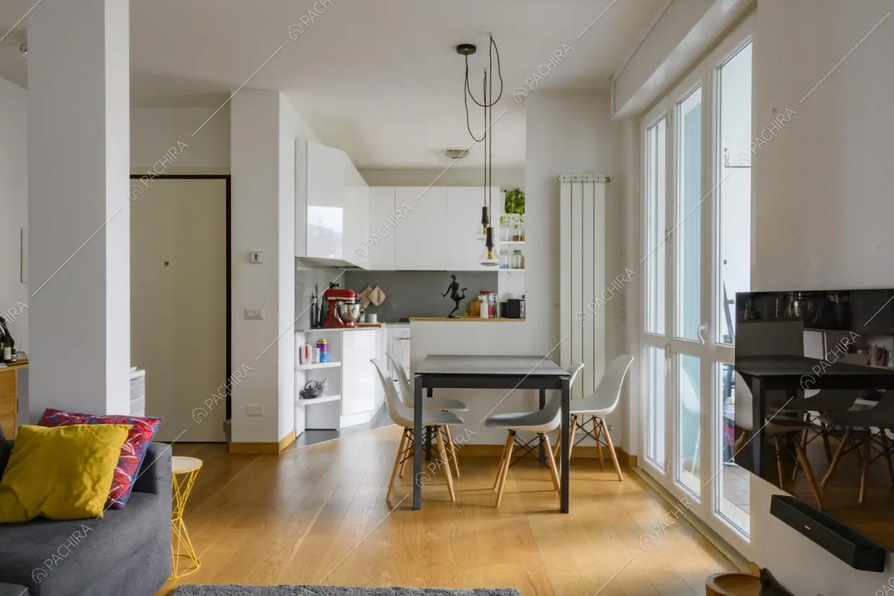 Zona pranzo con cucina a parete, tavolo con sedie e vetrata