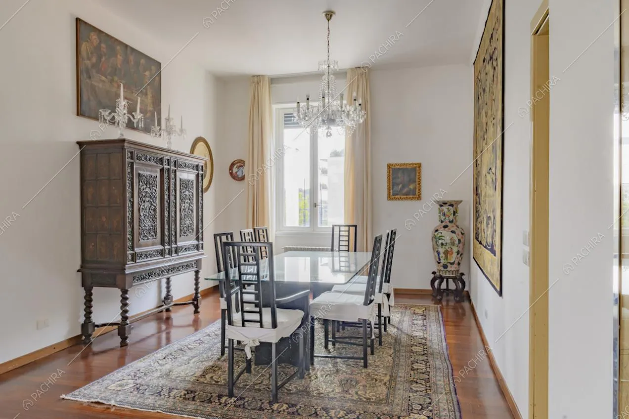 Sala da pranzo in stile classico, con pavimento in parquet, pareti bianche e lampadario antico