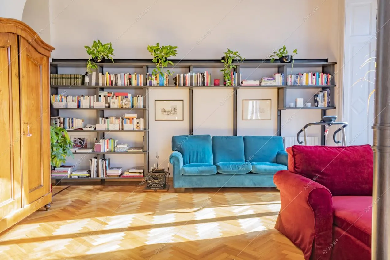 Vista sulla libreria a muro e parquet a spina di pesce