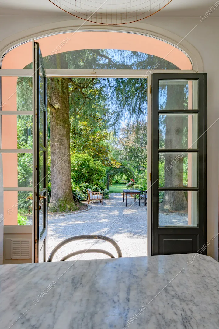 Dal tavolo della cucina con piano in marmo vista sul giardino tramite le porte-finestre