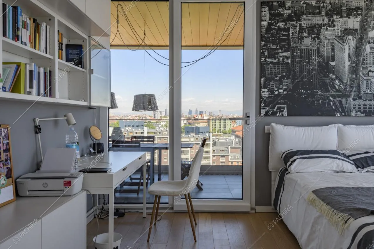 Camera da letto con scrivania e vista su skyline