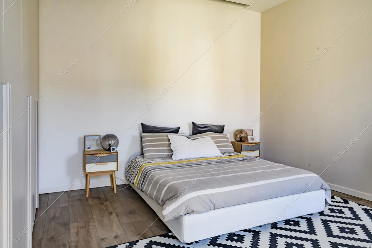 Letto matrimoniale con comodini in legno e tappeto