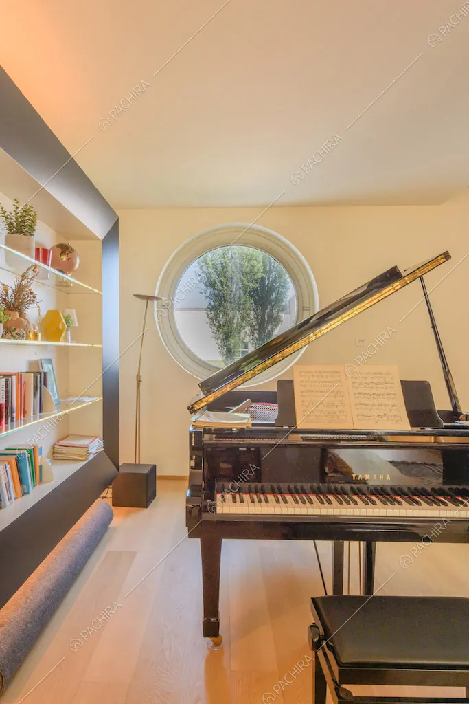 Pianoforte nero nel salotto con libreria e pavimento in parquet
