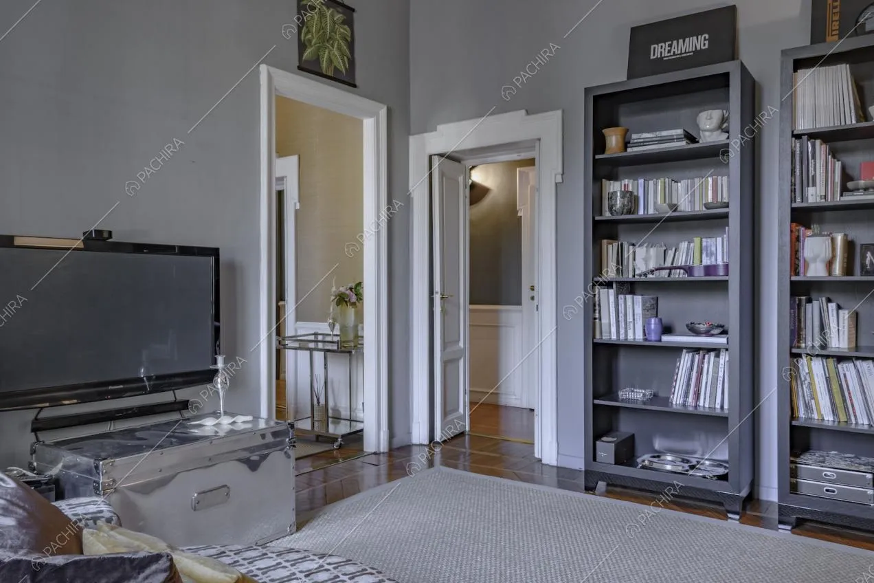 Librerie e grande tappeto su pavimento in parquet