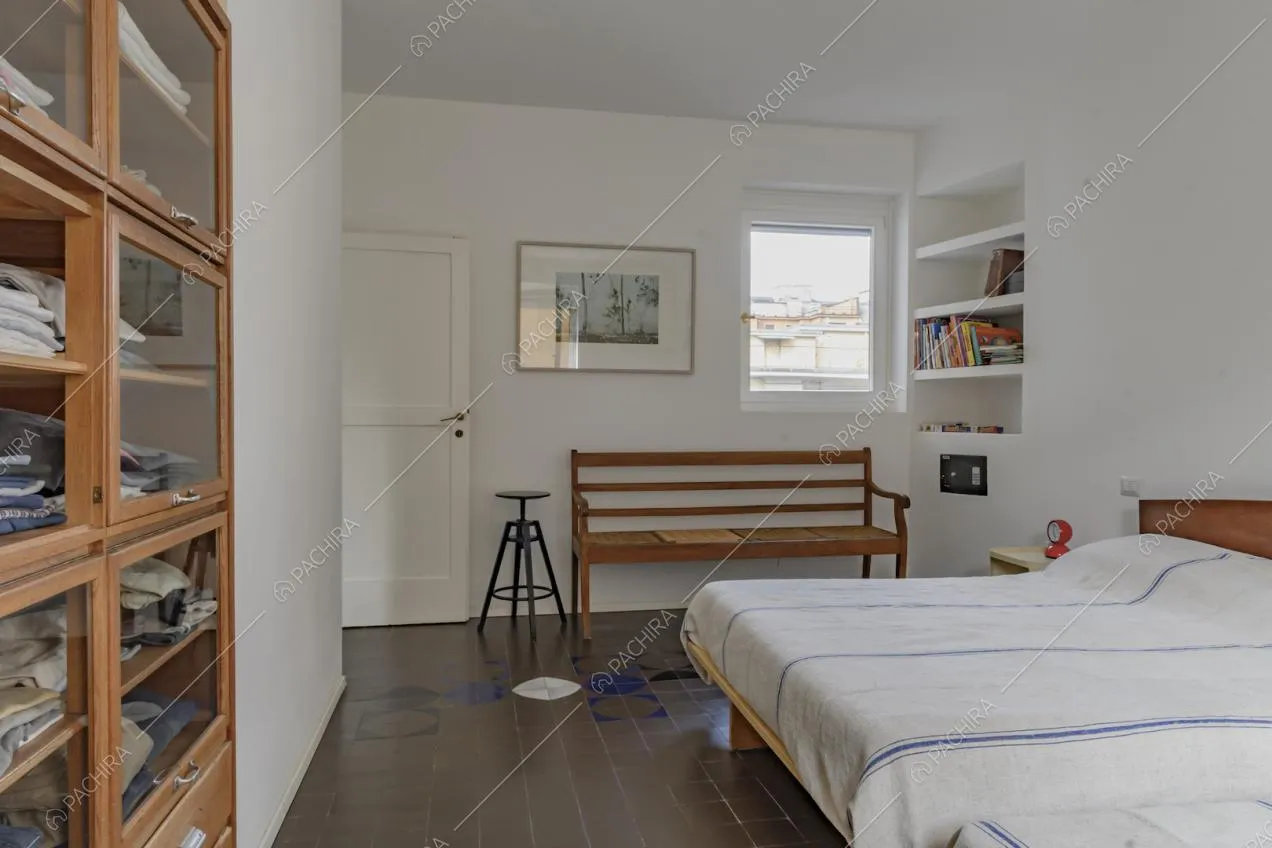 Camera da letto con piastrelle d'epoca e panca in legno