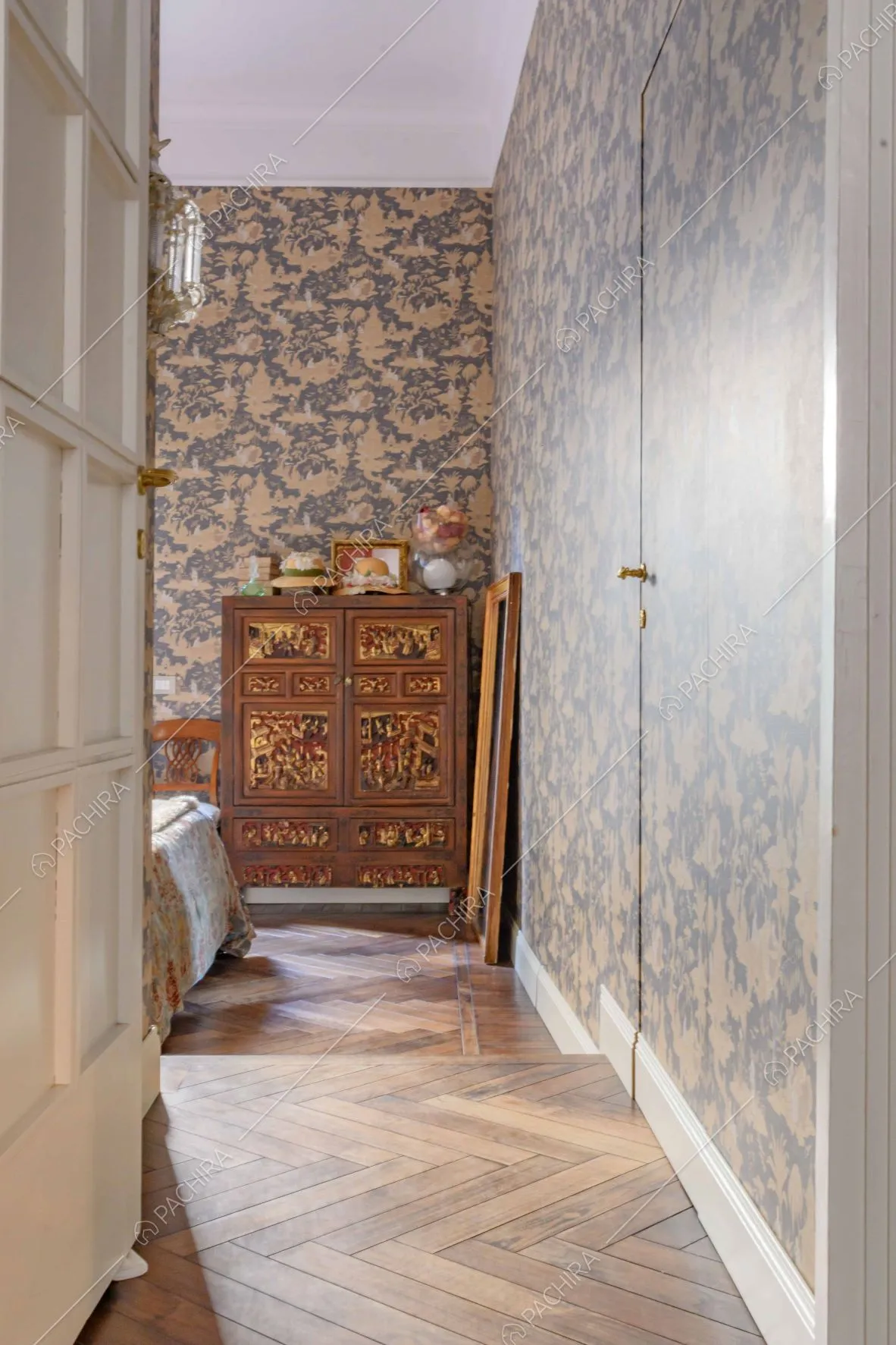 Dal corridoio vista sulla camera da letto matrimoniale con parquet a spina di pesce e carta da parati