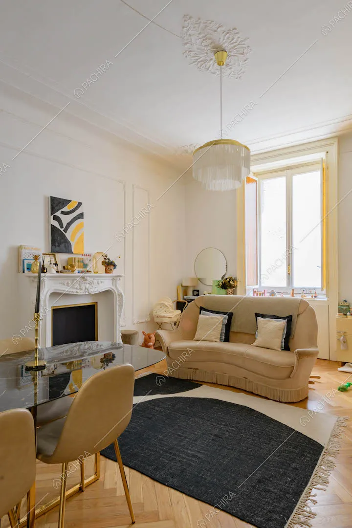 Luminoso salotto con camino, boiserie su pareti e soffitto e pavimento in parquet a spina di pesce