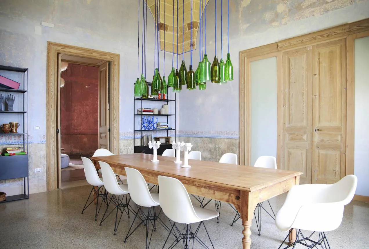 Tavolo in legno e sedie bianche nella sala da pranzo con pareti délabré