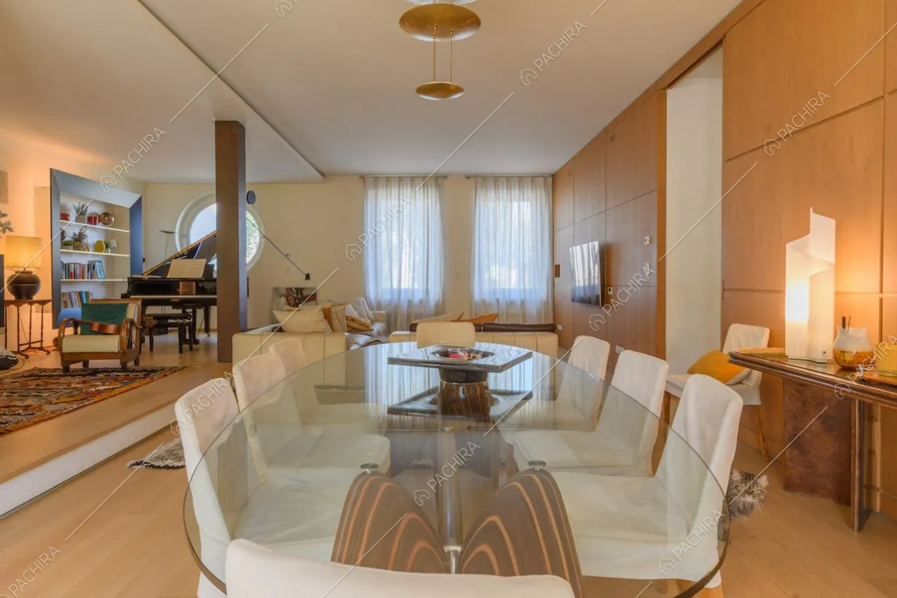Tavolo da pranzo con sedie bianche e pavimento in parquet