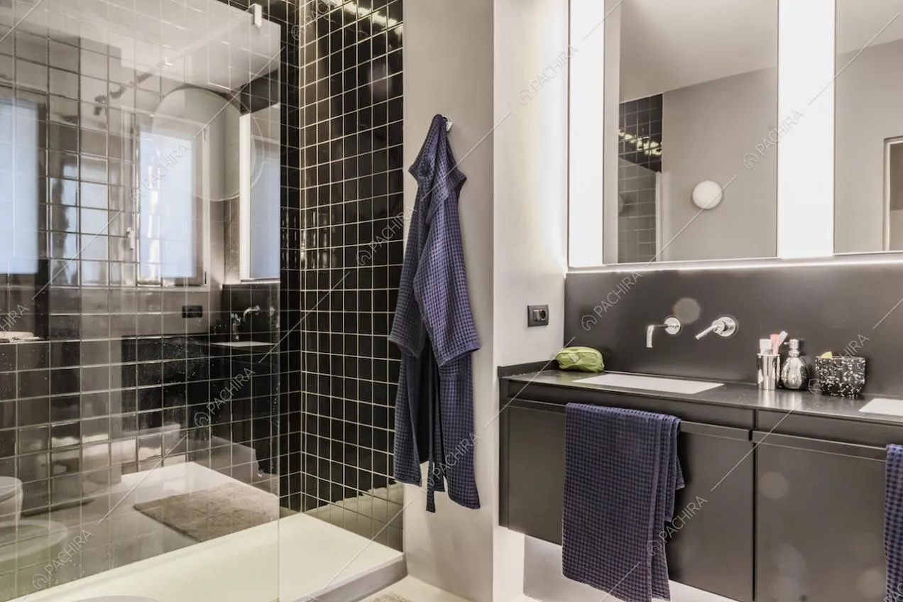 Bagno con piastrelle nere e cabina doccia