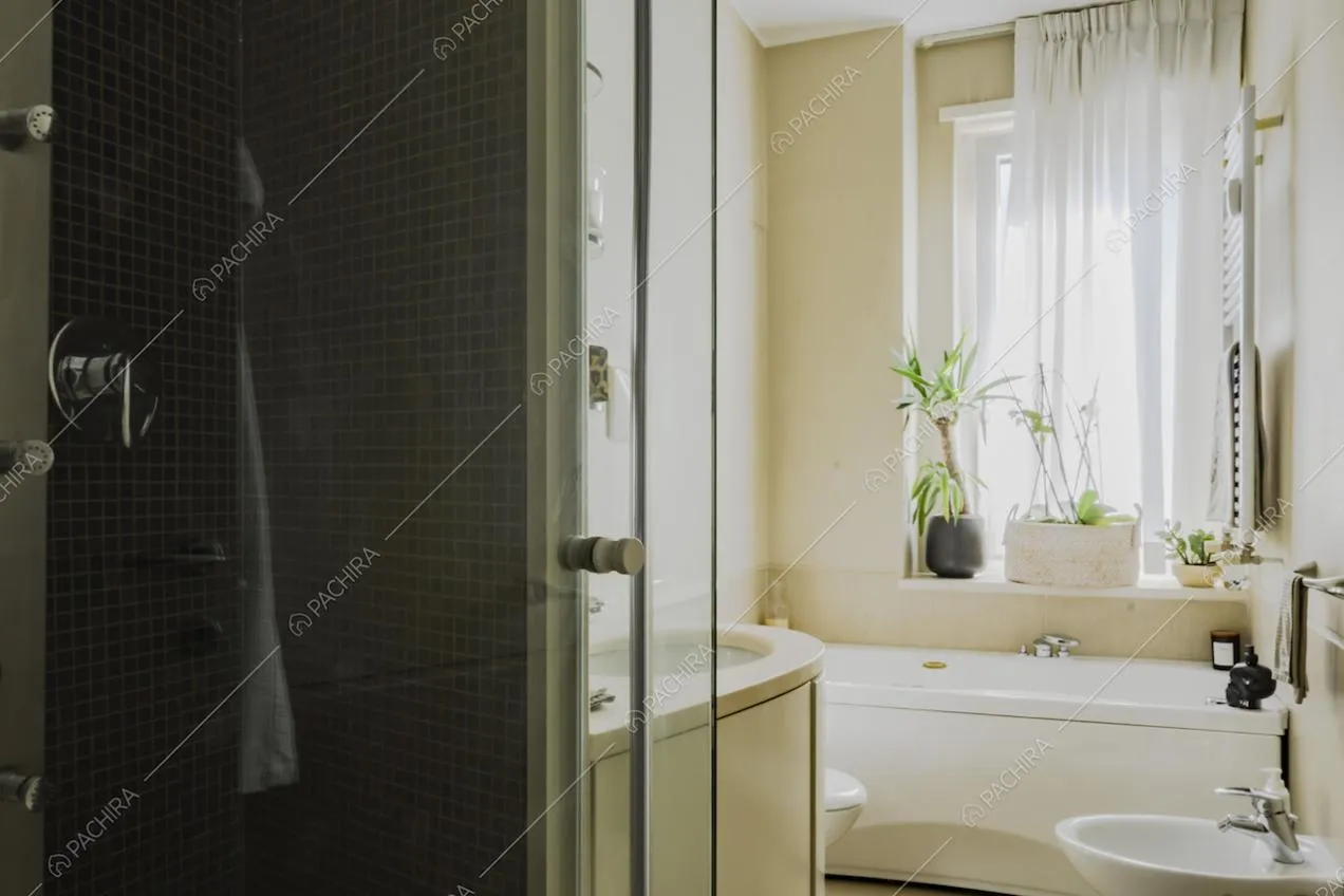 Vasca da bagno bianca e doccia con piastrelle a mosaico