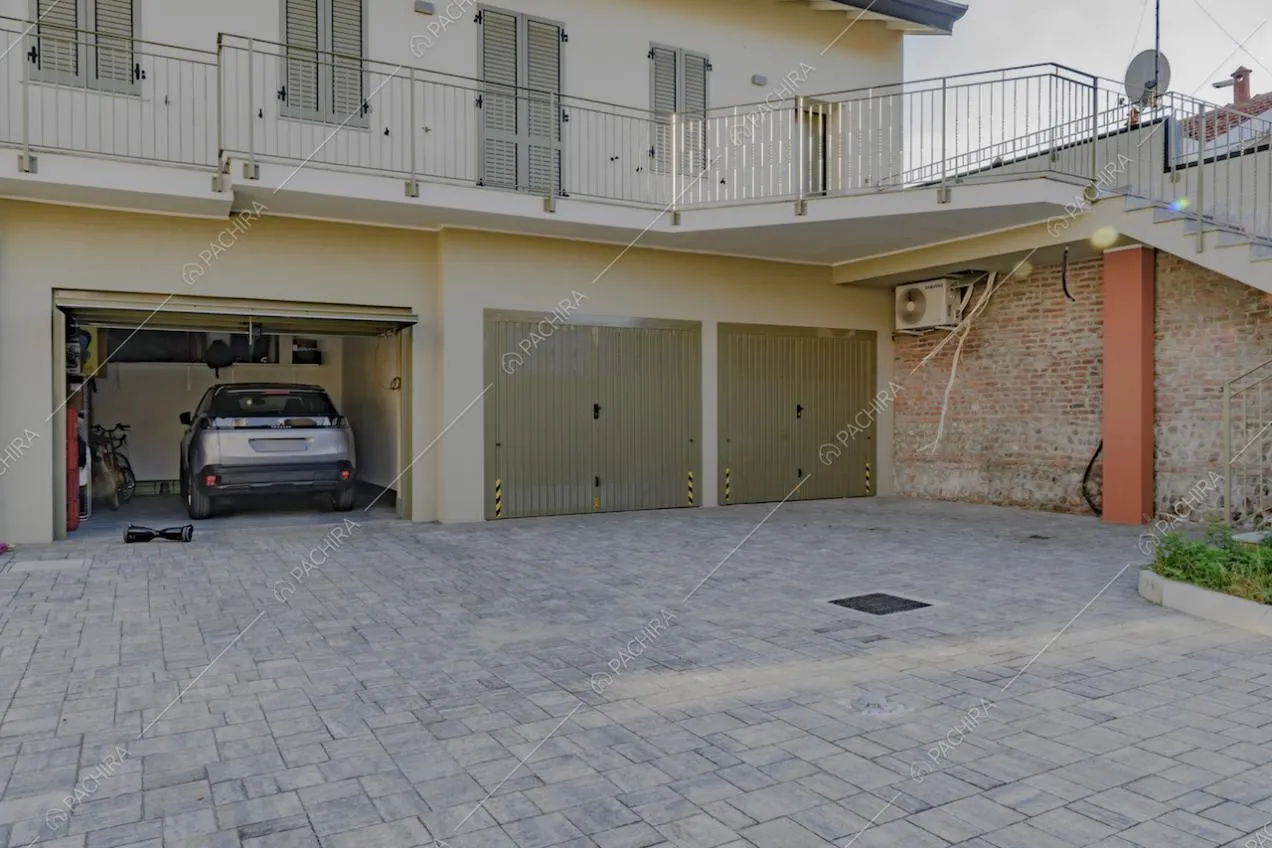 Garage nella corte con pavimentazione in pietra e ballatoio