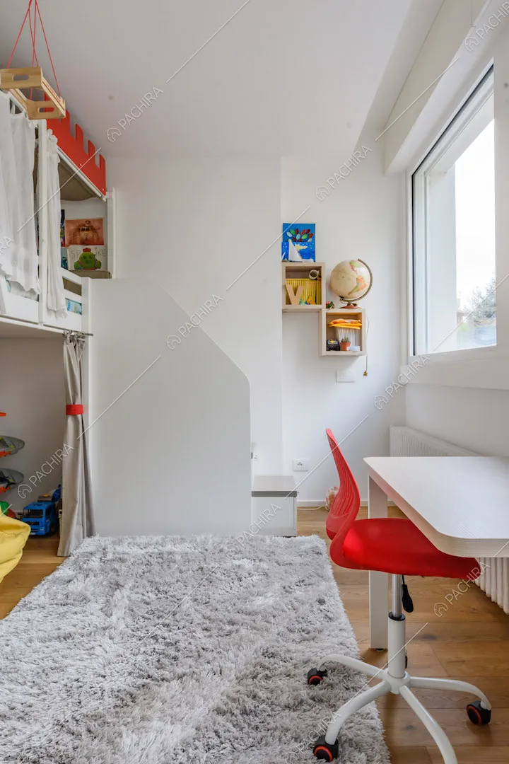 Camera da letto dei bambini con pareti bianche, soppalco e scrivania