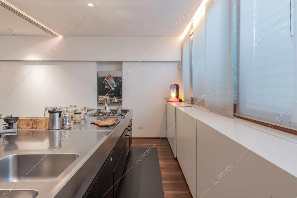 Isola in acciaio nella cucina dell'appartamento Carpentaria, location in stile contemporaneo a Roma