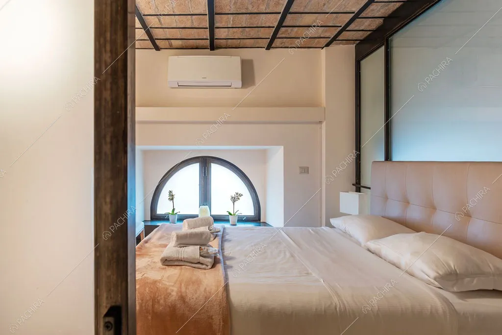Letto matrimoniale nella camera del loft Sabbia, location in stile moderno a Roma