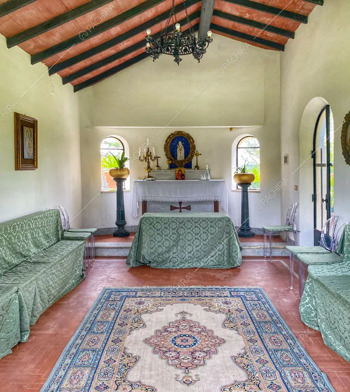 Cappella con travi a vista sul soffitto e pareti bianche