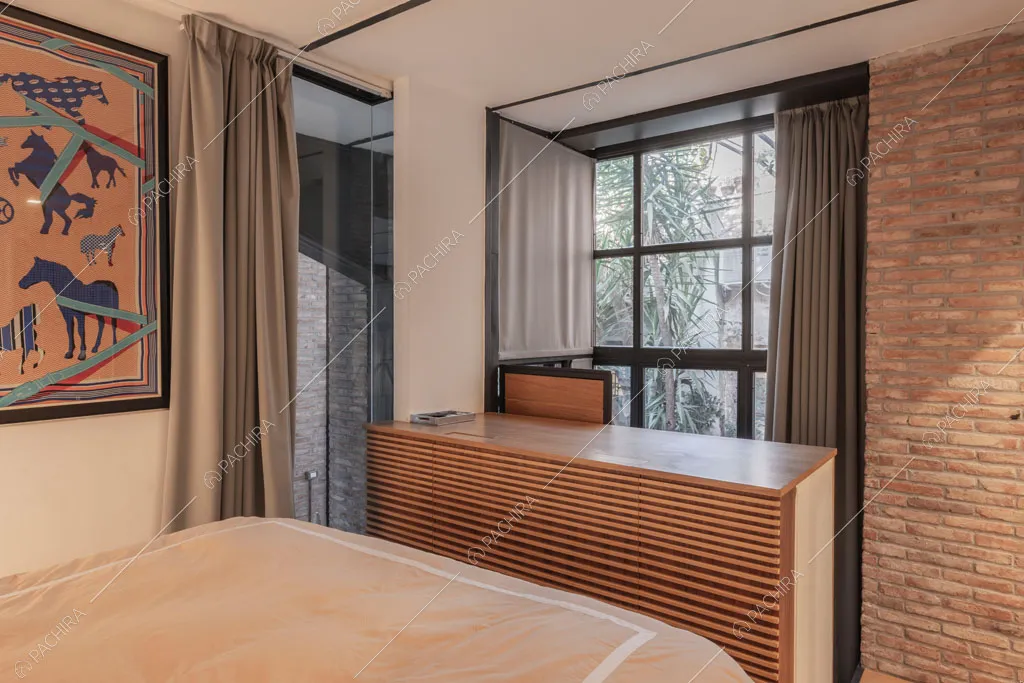 Parete con mattoni a vista nella camera da letto del loft Berillio, location in stile contemporaneo a Roma