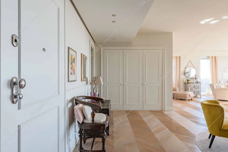 Luminoso atrio con pavimento in parquet a spina di pesce e pareti bianche
