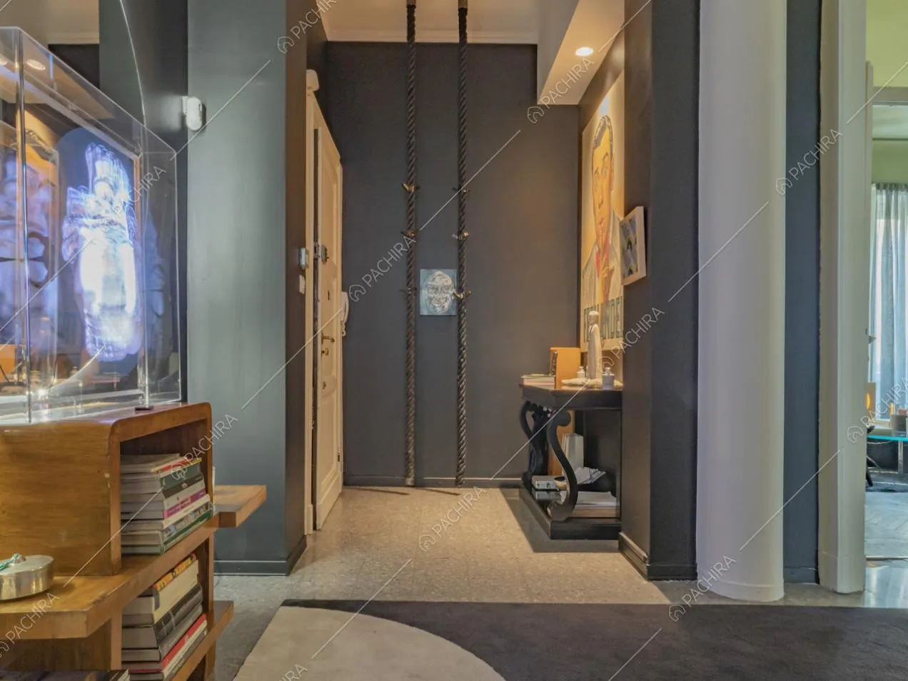 Mobile di legno con libri, pareti nere e porta d'ingresso bianca