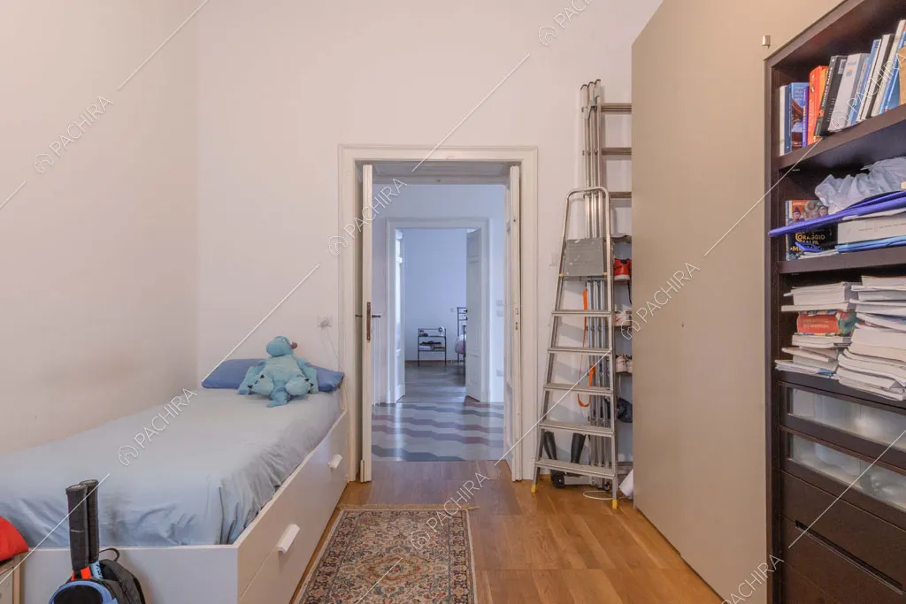 Camera con letto singolo, grande armadio e pavimento in parquet