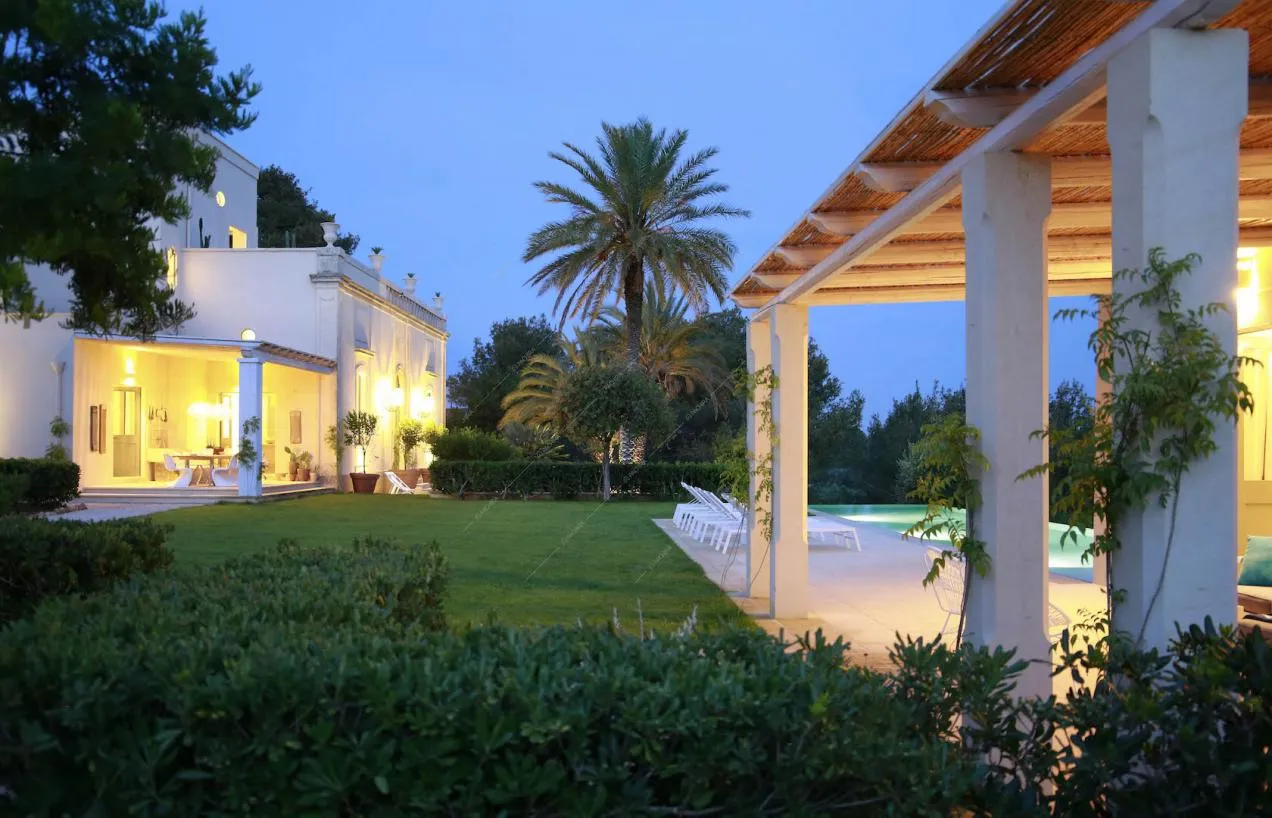 Dalla veranda del giardino vista sulla piscina e sulla villa bianca