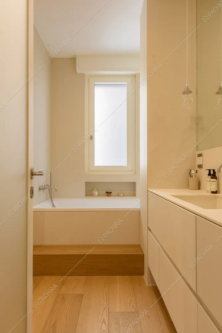 Bagno con pavimento in parquet, mobile sospeso e grande vasca