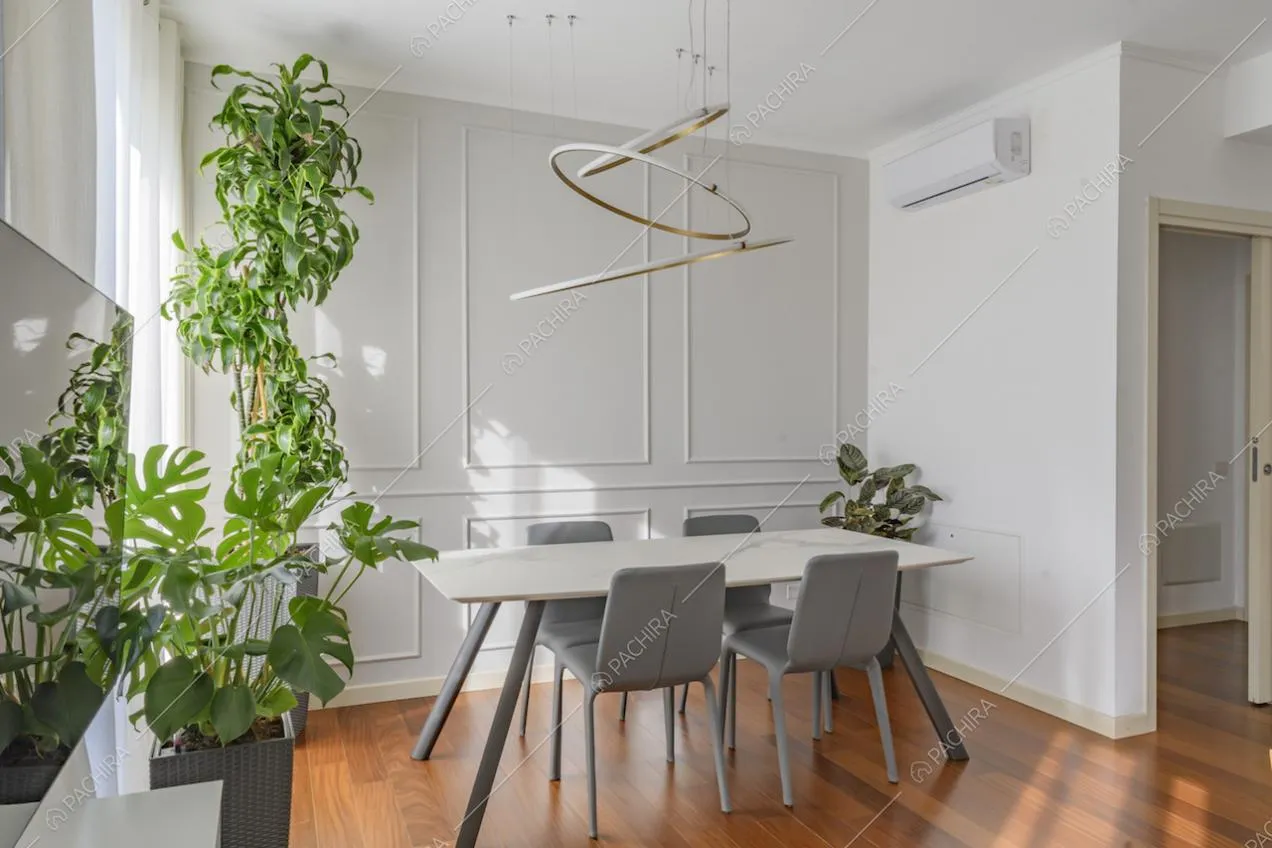 Sala da pranzo con boiserie alle pareti bianche e arredamento di design