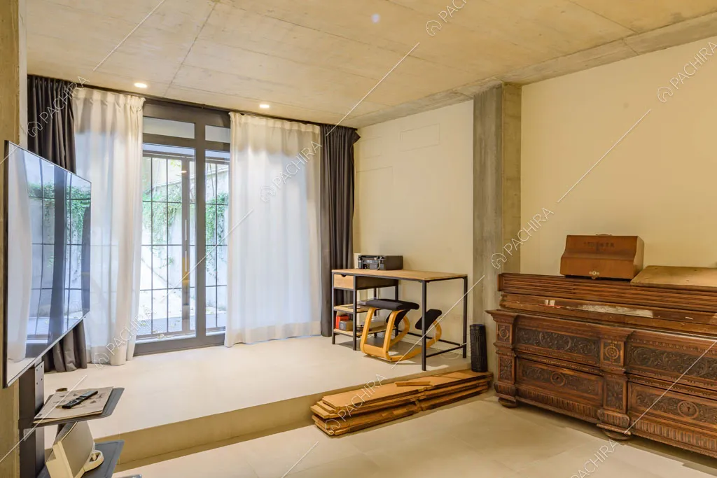 Luminosa stanza con soffitto in cemento e credenza antica