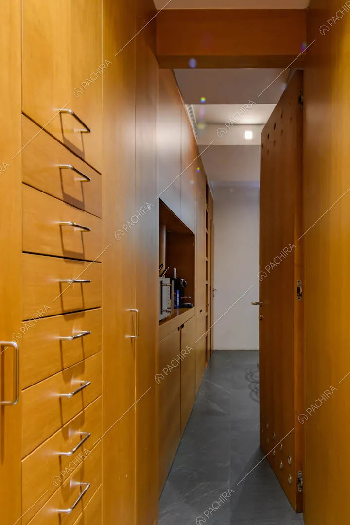Corridoio con pareti e cassetti in legno per accedere alla cucina